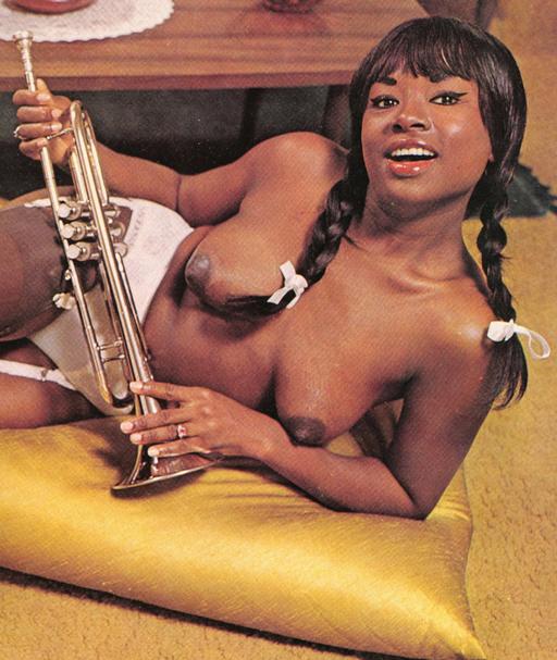 black girl with pigtails and a brass instrument shows off her pretty boobs